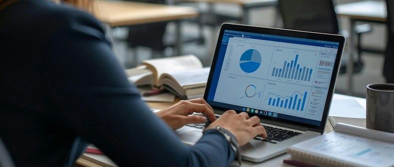 Woman working on laptop with charts and graphs.